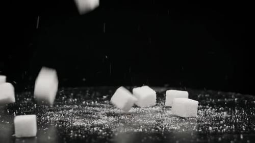 Sugar Cubes Fall on Rotating Table on Black Background in Slow Motion Close Up