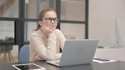 Pensive Young Woman Sitting in Office