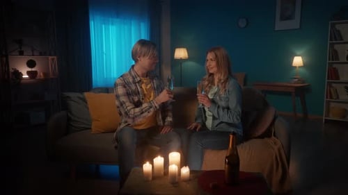 Couple Cheers Champagne in Candlelight Home Setting