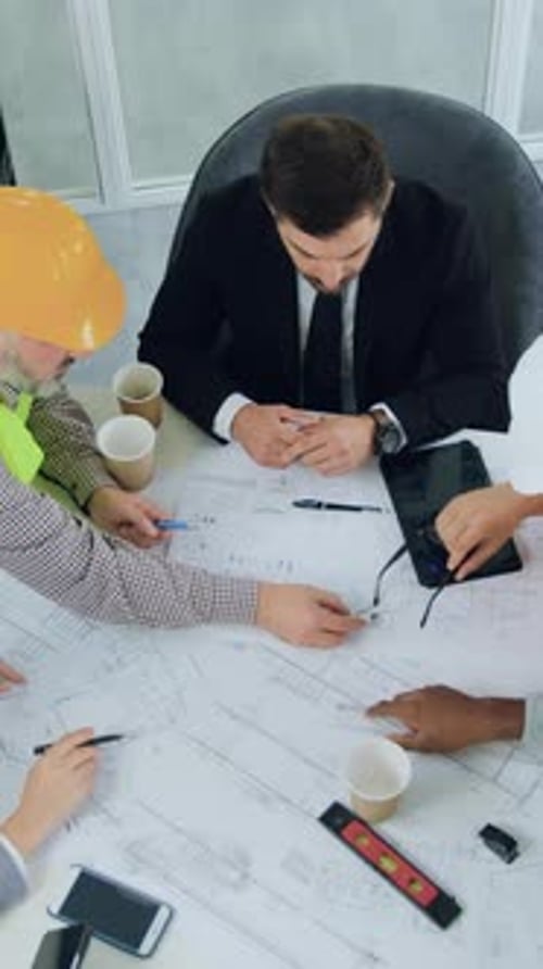 Business Team Discussing Blueprint in Office Meeting