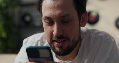 Smiling Man Checks Phone in Close Up Shot