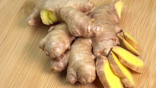 Fresh whole ginger root rotate on wooden background close up. Spices and herbs seasoning for cook