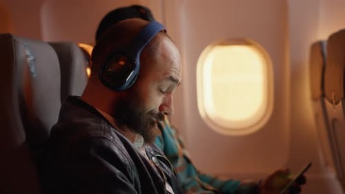 Men on Airplane Using Laptop and Smartphone