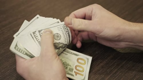 Male Hands Counting Hundred Dollar Bills Against Table Top View Slow Motion