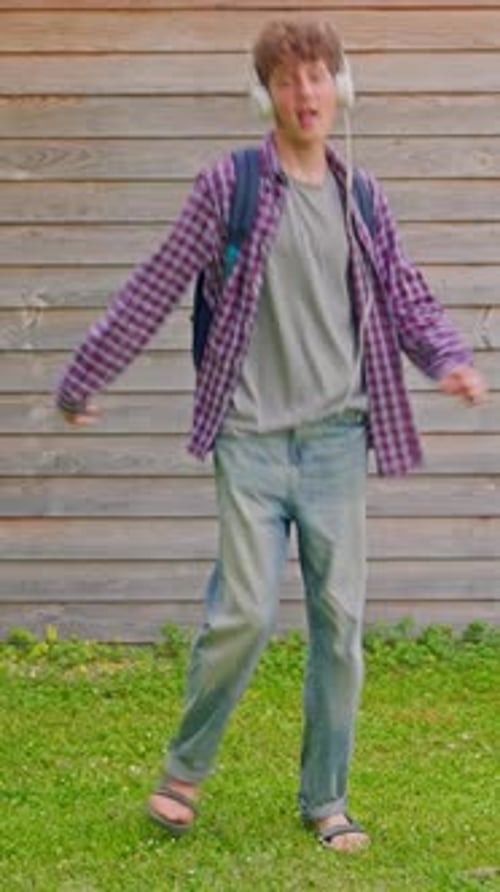 Young Adult Dancing Outdoors with Headphones