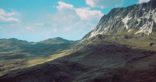 Majestic Mountain Landscape Under Blue Sky with Fluffy Clouds at Dusk