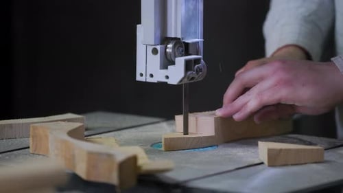 A man works with wood in a workshop. Working with wooden blanks. A man drills holes in wooden blanks