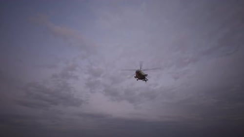 Military Helicopter Flying Against Cloudy Sky