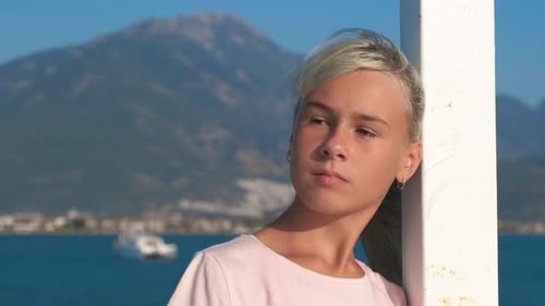 Nachdenklicher Teenager am Pier im Meer.