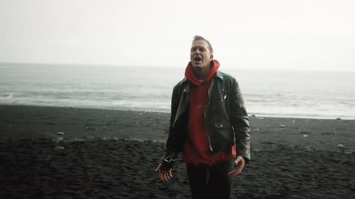 Goodlooking Young Man Singing on a Rainy Day on Reynisfjara Beach Iceland