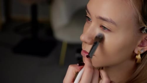 Visagist trägt Concealer auf das Model auf