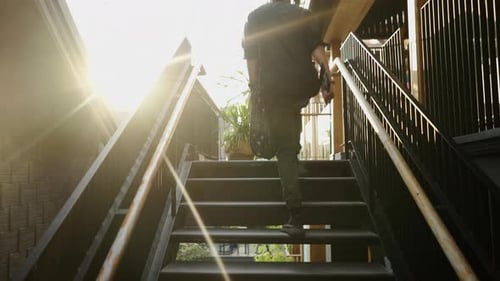 Camera Follows a Tall Man in a Black Shirt in an Outside Office