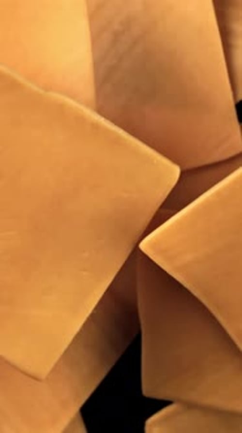 Sliced Cheddar Cheese Flies on a Black Background Filmed on a Highspeed Camera at 1000 Fps