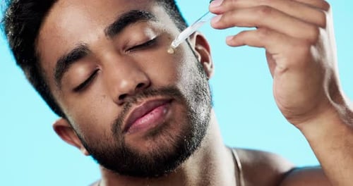 Skincare, health and man with face serum in a studio with a beauty, grooming and face routine