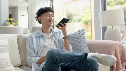 Young Man Talking on Phone Sitting on Couch