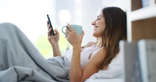 Woman Relaxes in Bed with Phone and Coffee