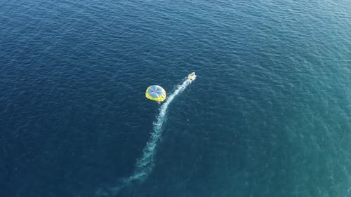 Aerial view of a person doing parasail in Sicily, Italy.