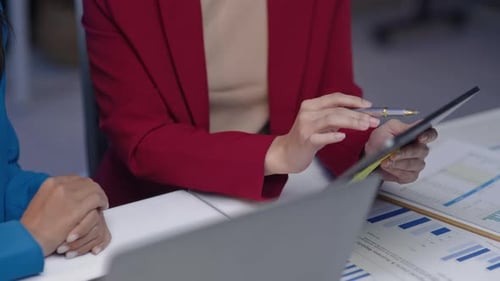Businesswomen Discussing Data Analysis at Desk
