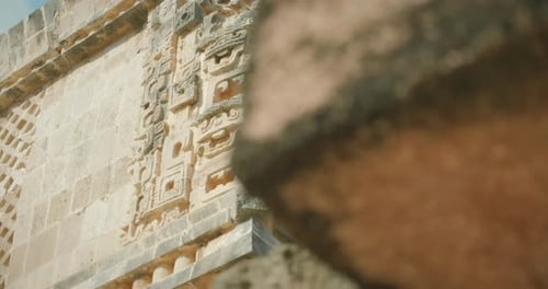 Detailed ornate Mayan stone carving on temple corner ancient ruins building