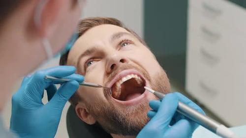 Treatment of Teeth in a Male Patient a Dentist Performs a Hygienic Cleaning of the Teeth From Caries