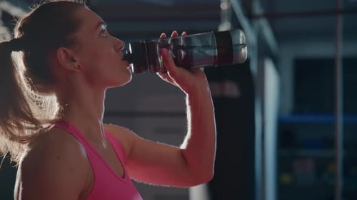 Woman Hydrates in Gym After Workout