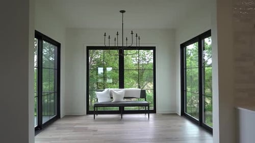 Mid century modern 4 seasons room overlooking a forest.