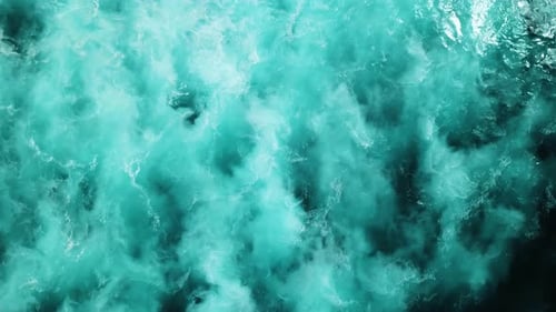 Aerial shot directly above the choppy white-wash ocean waters on a stormy day in the Pacific Ocean.