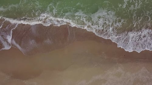Aerial Top Down View of Tranquil Empty Beach Foamy Ocean Waves Washing Sand on Shore Sea Waves