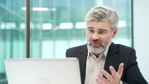 Man Looks Concerned at Laptop in Office