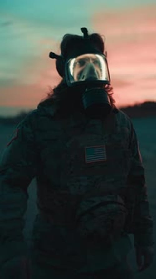 American Soldier Walks on Beach at Sunset Ready for Attack Wearing Gas Mask