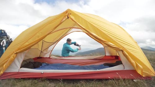 Man Camping, Pouring Drink on Mountain Top