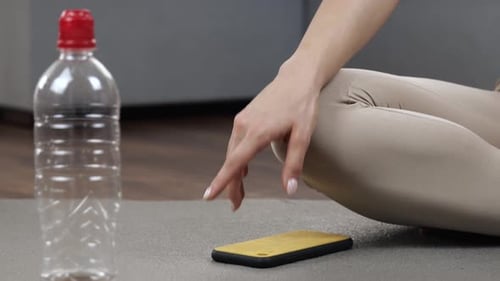 Woman on Yoga Mat Puts Down Cell Phone