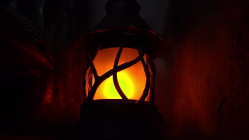 Kerosene lamp light or an ancient lantern flickers in the dark. Old classic oil lantern burning