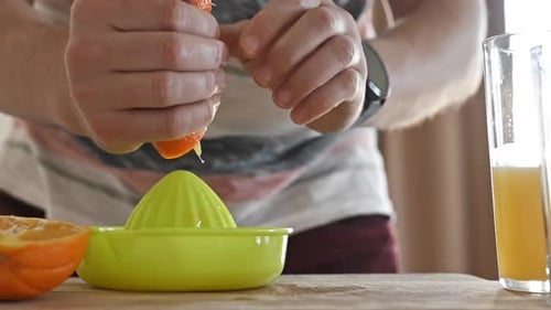 Man Hand Juicing Fresh Orange for Nutritious Drink