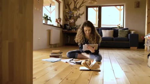 Woman Studying on Floor with Tablet and Books