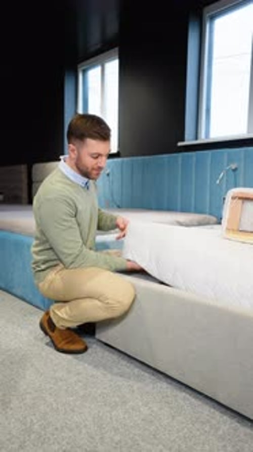 Young Handsome Man Examining Orthopedic Mattress at Furniture Store Vertical Video