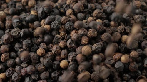 Close Up of Black Peppercorns Falling