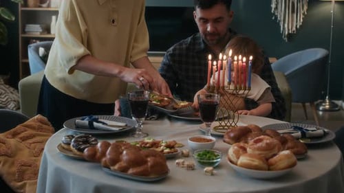 Family celebrates Hanukkah with menorah and traditional foods