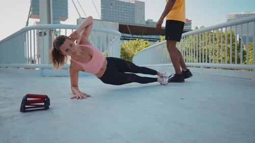 Woman Doing a Side Plank on Urban Bridge