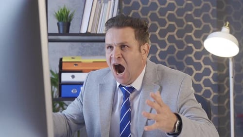 Unsuccessful office worker. Businessman looks at computer and gets angry.