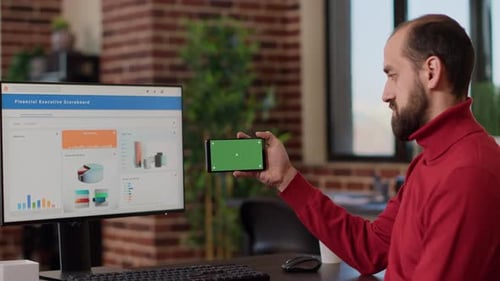 Male Worker Holding Smartphone with Horizontal Green Screen