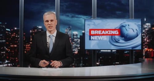 Periodista masculino maduro y seguro de sí mismo presenta una cobertura de noticias urgente en un estudio de televisión profesional