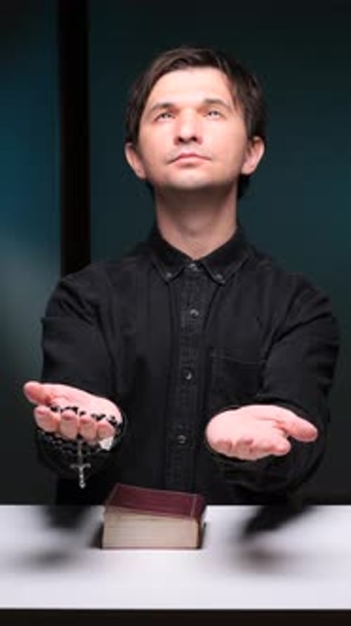 Vertical Video Priest Praying with Rosary and Bible on White Table