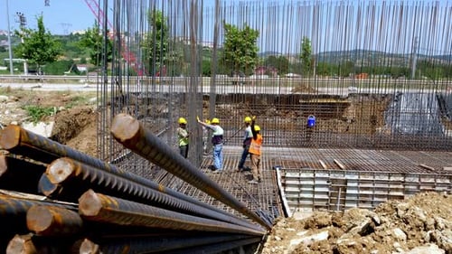 Construction Workers on Steel Rebar Grid at Daytime Building Site