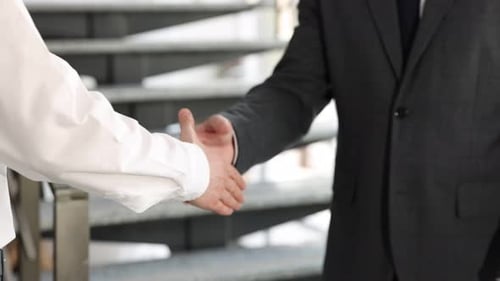 Man and woman shaking hands indoors, closeup
