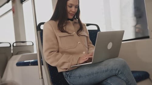 Woman Working on Laptop During Public Transport Commute