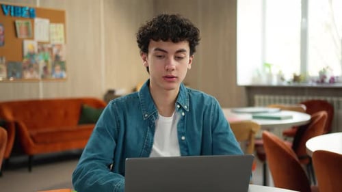 Teen Works on Laptop in Modern Setting