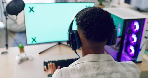 A gamer playing a video game on the computer using a neon keyboard and wired mouse, chroma key