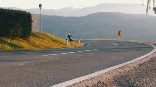 Moto Biker Rides on a Mountain Road From the Turn Landscape View of the Alps Mountains Austria