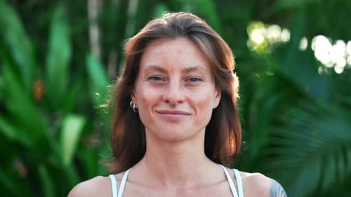 Happy Portrait of Beautiful Woman at Green Nature Looking at Camera and Smiling